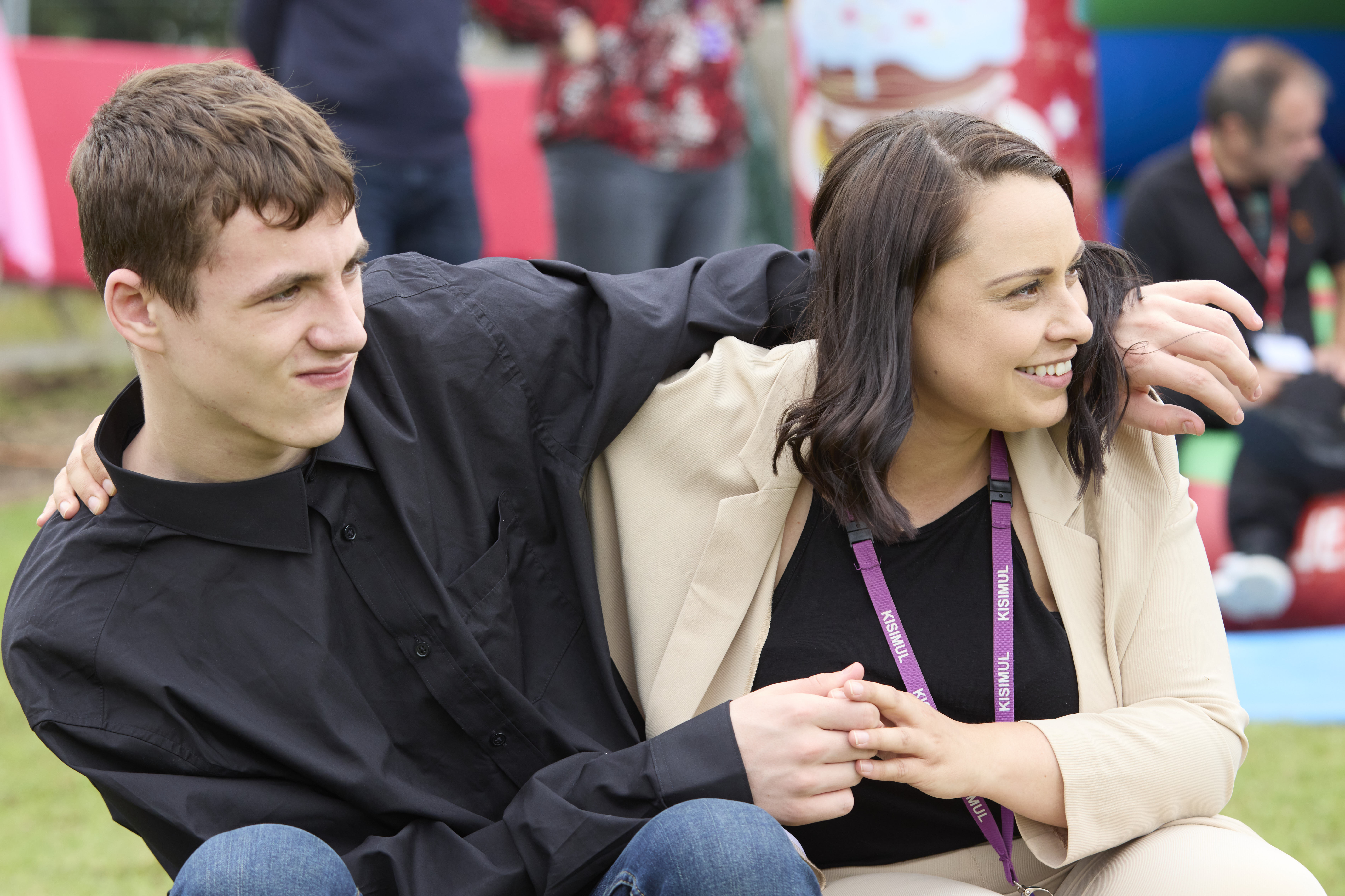 Man with arm around woman, holding hands.