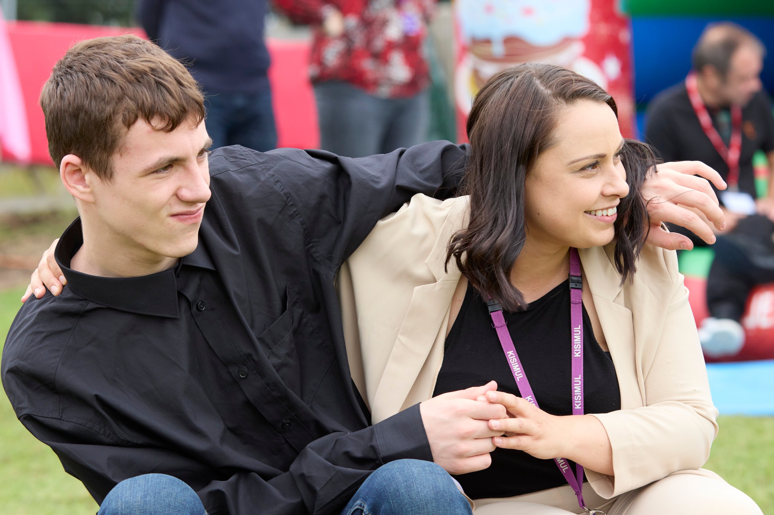 Man with arm around woman, holding hands.